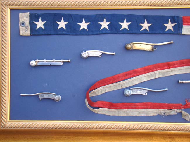 A framed collection of 8 bosuns' whistles and a ships pennant — image 3